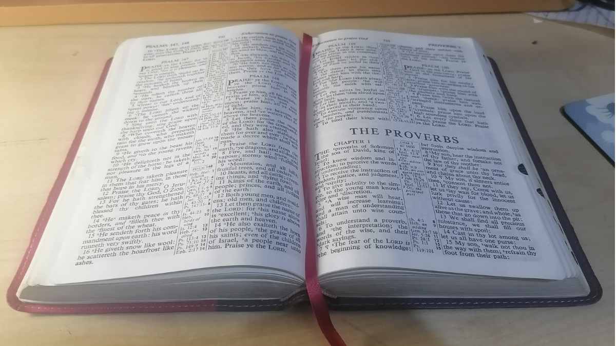 A bible on the table with the book of proverbs open